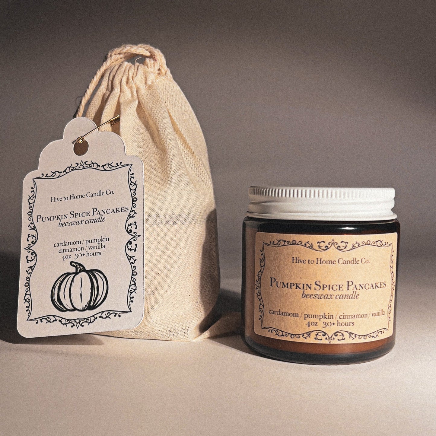 Pumpkin spice fall candle with label and drawstring bag on a neutral background