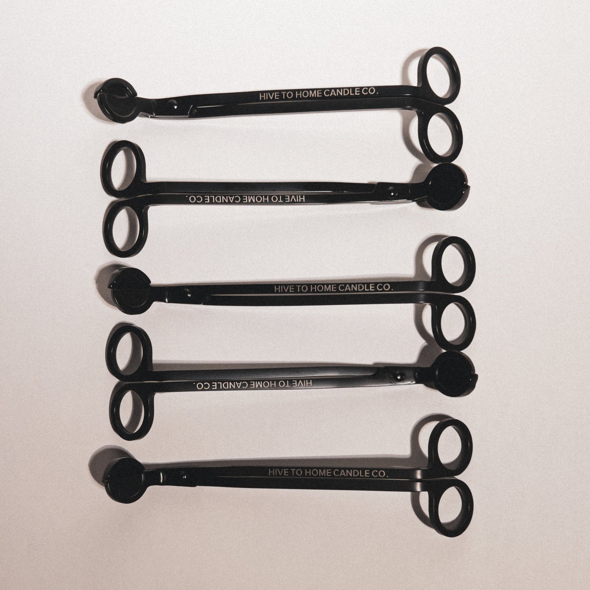Multiple candle wick trimmers laid out in decorative manor.