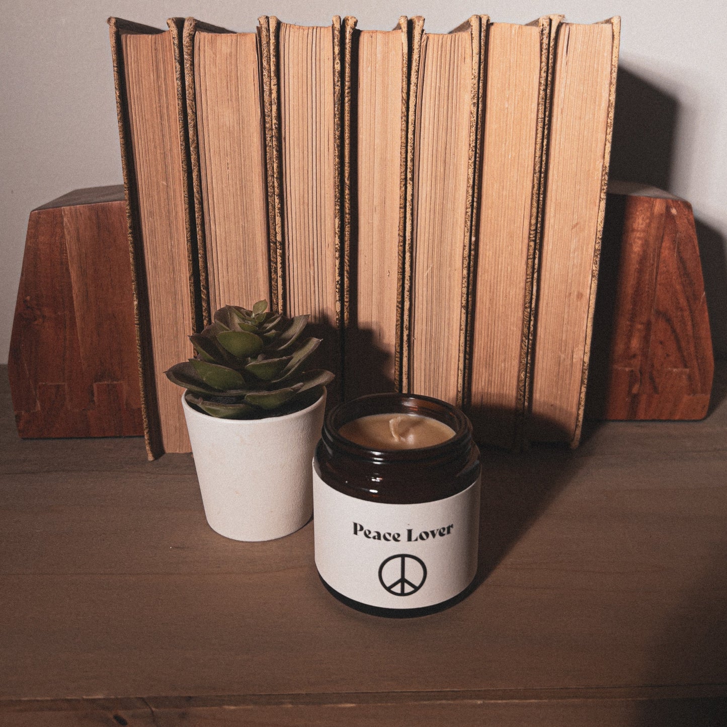Peace Lover Palo Santo & Patchouli Scented Beeswax Candle with old worn books home decor.