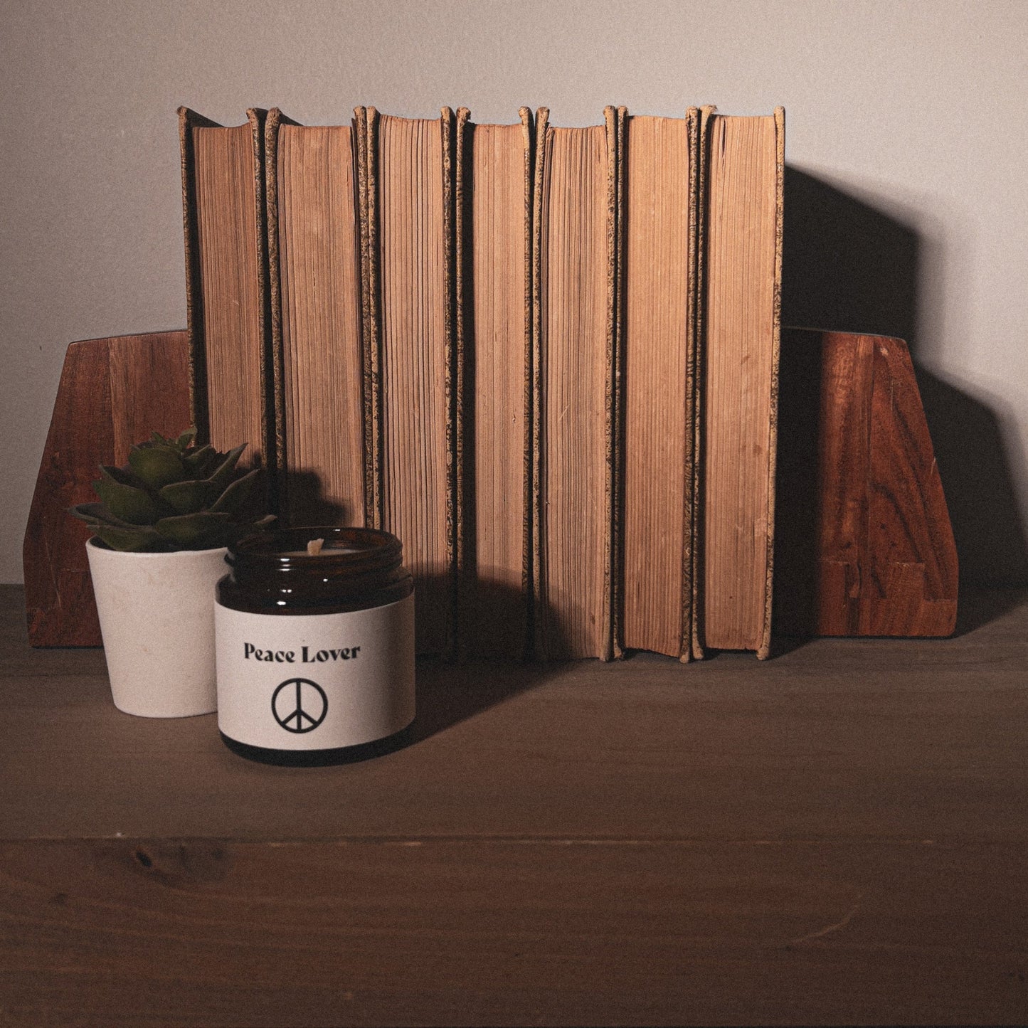Peace Lover 4 oz beeswax candle with old worn books on bookshelf home decor.