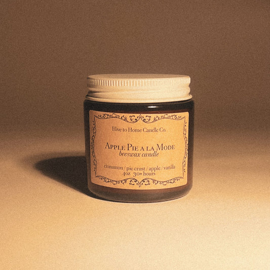 4 oz fall scented candle smells like baked apple pie with a brown label in amber glass jar with white lid.