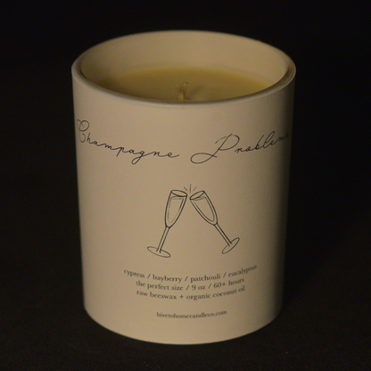 Unlit scented beeswax candle. Champagne Problems scented candle.