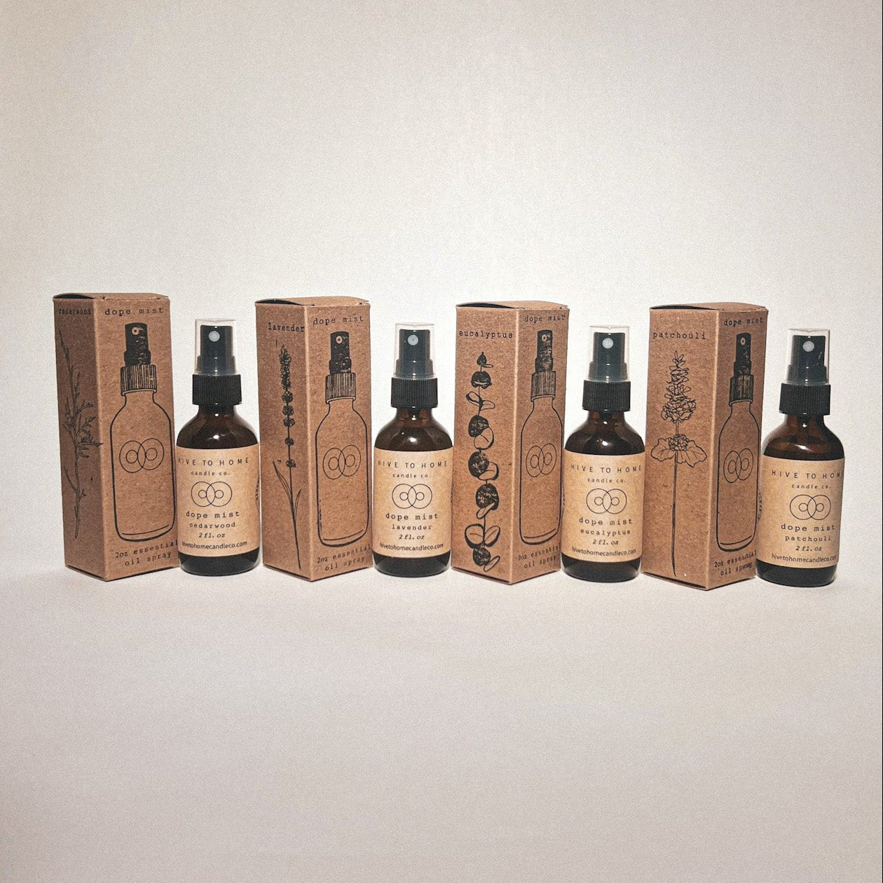 Each of our 2 oz Essential Oil Scent Sprays; lavender, cedar wood, eucalyptus, & patchouli with their hand stamped boxes. Spray bottle line art and drawn plants.