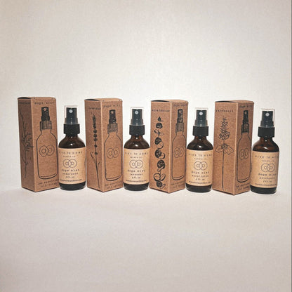 Each of our 2 oz Essential Oil Scent Sprays; lavender, cedar wood, eucalyptus, & patchouli with their hand stamped boxes. Spray bottle line art and drawn plants.