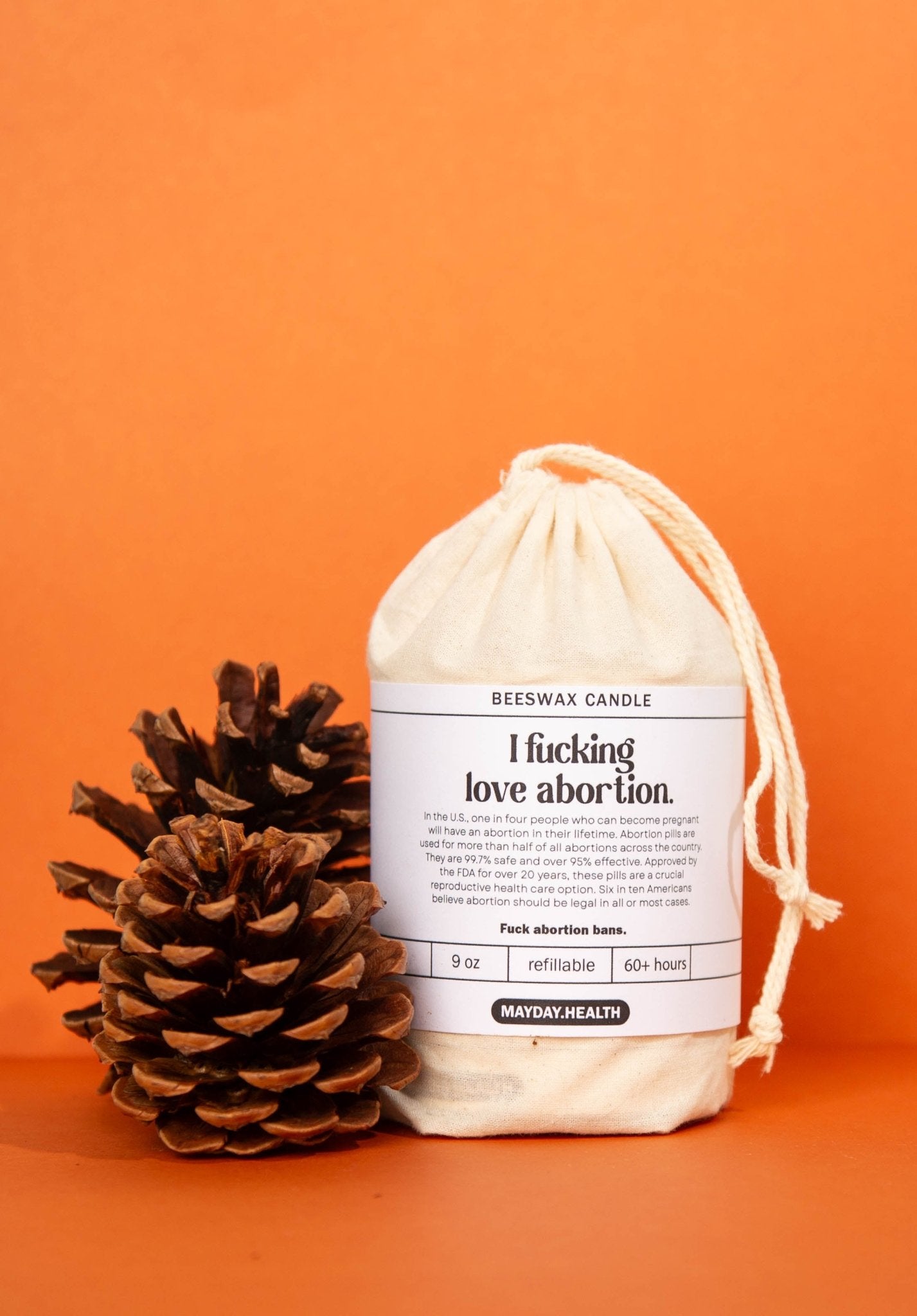 fall candle in packaging with pine cones, mayday health and hive to home candle co candle